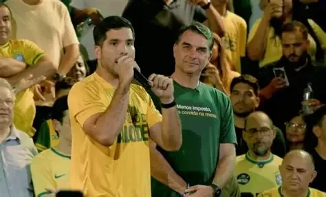 Flávio Bolsonaro acenando para apoiadores durante evento político em Fortaleza.