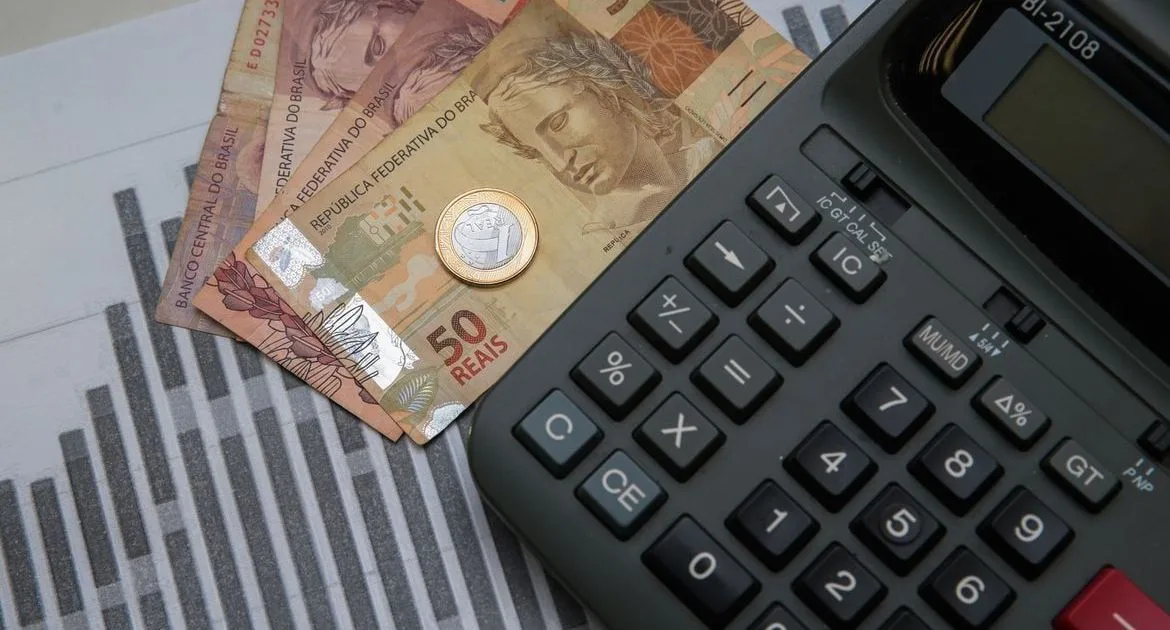 Equipe de gestão analisando documentos financeiros e gráficos sobre a mesa.