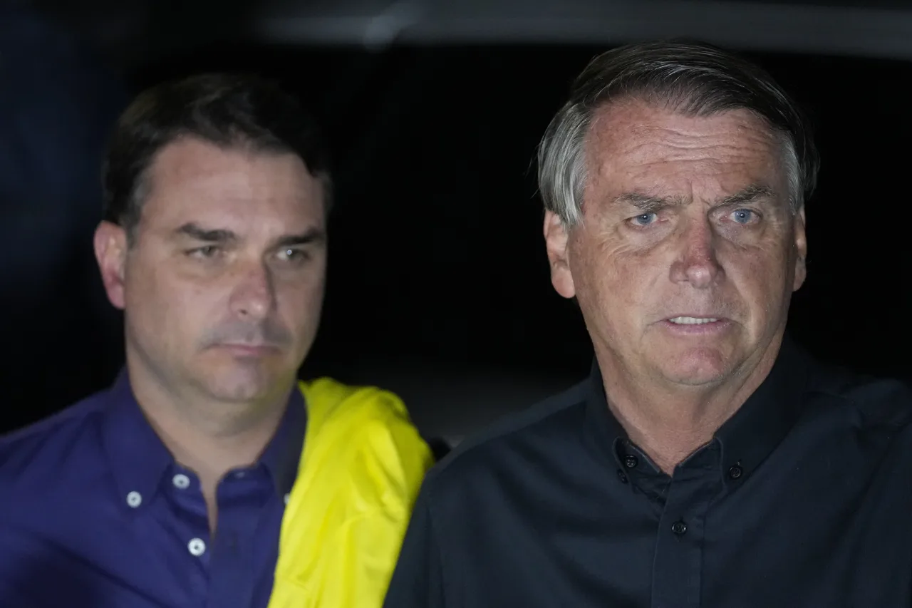 Flávio Bolsonaro e Jair Bolsonaro lado a lado em registro fotográfico.