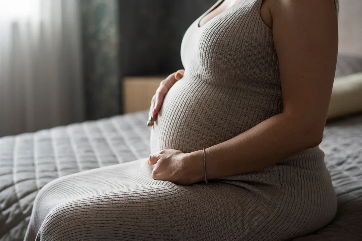 Mulher grávida em ambiente doméstico.
