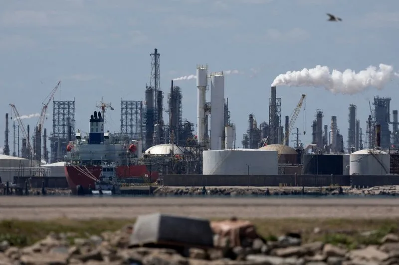 Barril de petróleo em destaque com fundo de plataforma offshore.