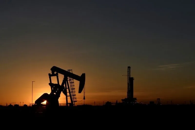 Tanques de armazenamento de petróleo sob céu nublado.