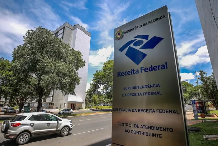 Fachada do prédio da Receita Federal com documentos fiscais em destaque.