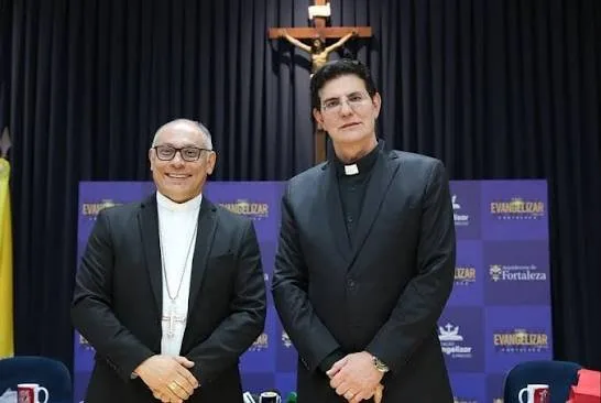 Público reunido em evento católico ao ar livre com palco montado.