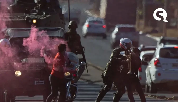 Militantes jogam bomba de fumaça durante desfile de tanques