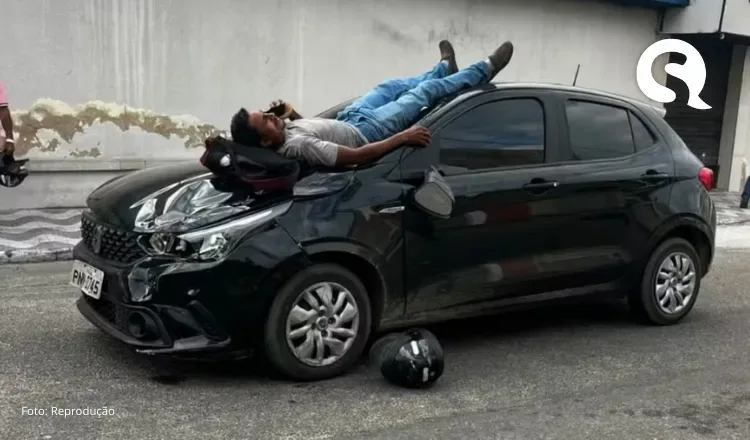 Motociclista cai sobre capô de carro após acidente e usa celular enquanto aguarda socorro
